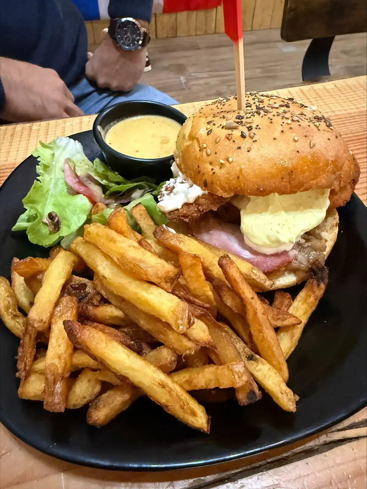 Un burger et une assiette de frites maison, sauce à part.
