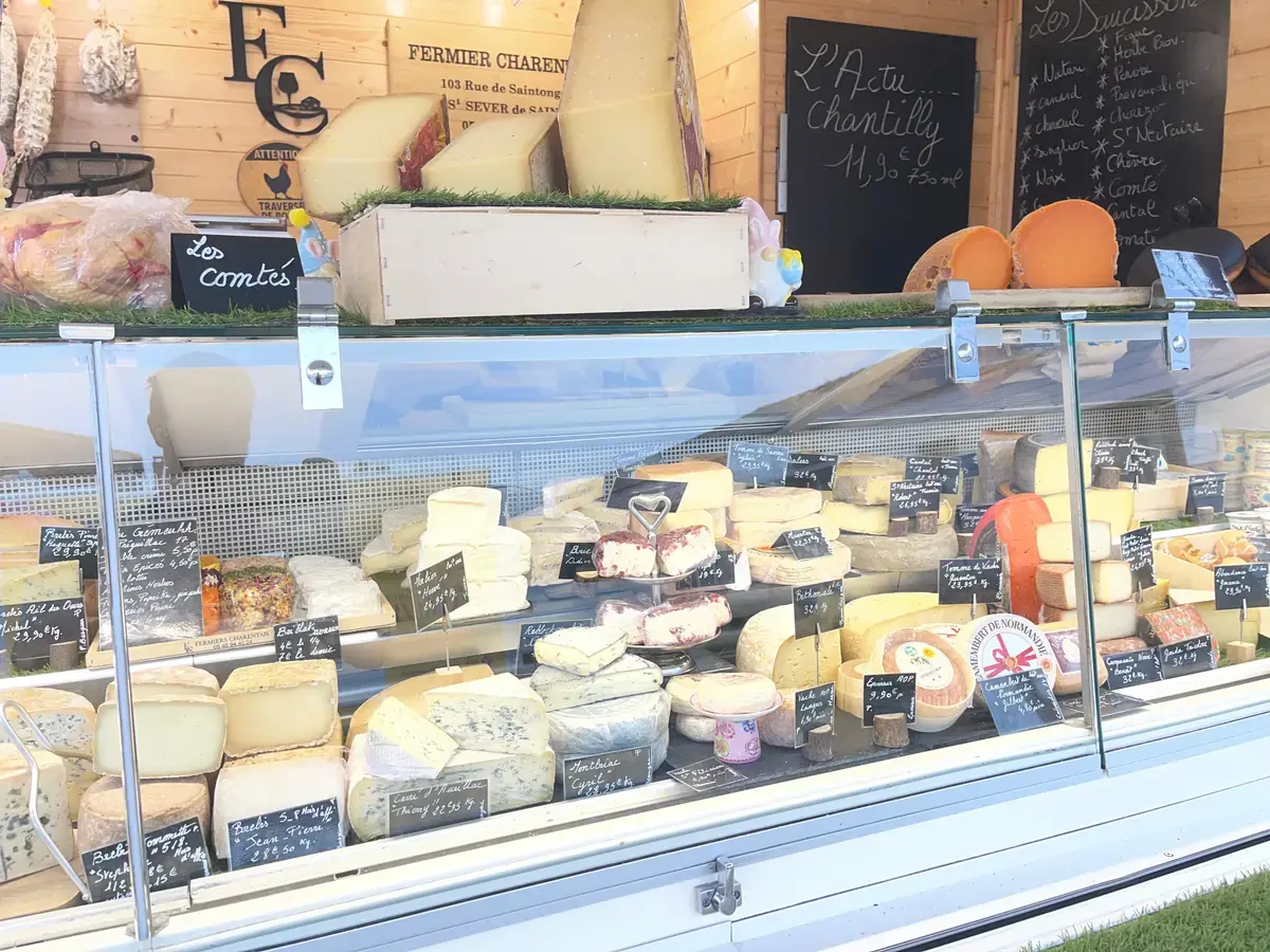 La vitrine réfrigérée du camion, garnie de fromages et d’ardoises écrites à la craie.